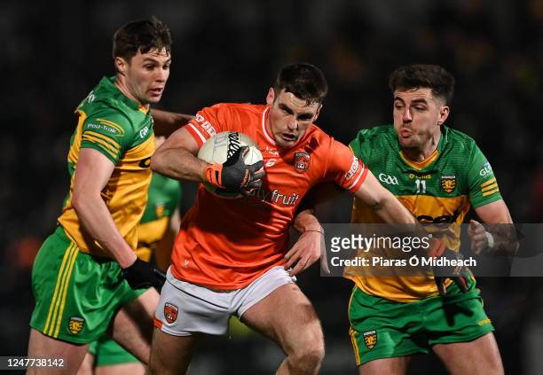Armagh , United Kingdom - 4 March 2023; Greg McCabe of Armagh is tackled by Conor O'Donnell, left, and Dáire Ó Baoill of Donegal during the Allianz...