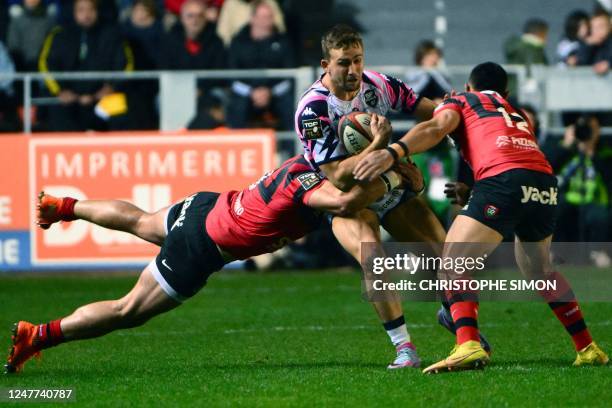 Stade Francais' French hooker Laurent Panis is tackled by Toulon's Argentinian number 8 Facundo Isa and Toulon's Australian centre Duncan Paia'aua...