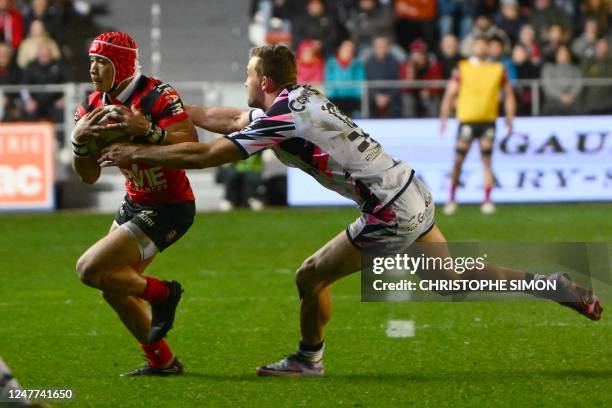 Toulon's South African wing Cheslin Kolbe is tackled by Stade Francais' French centre Julien Delbouis during to the French Top 14 rugby union match...