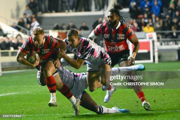 Toulon's New Zealand fly-half Ihaia West is tackled by Stade Francais' South African centre Jeremy Ward during to the French Top 14 rugby union match...