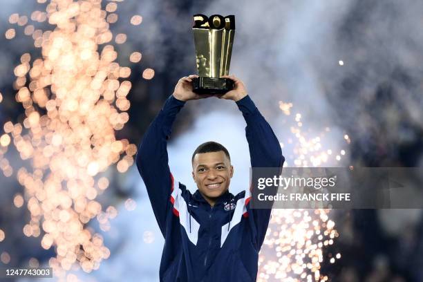 Paris Saint-Germain's French forward Kylian Mbappe raises a trophy during a ceremony after he became Paris Saint-Germain's all-time top scorer with...