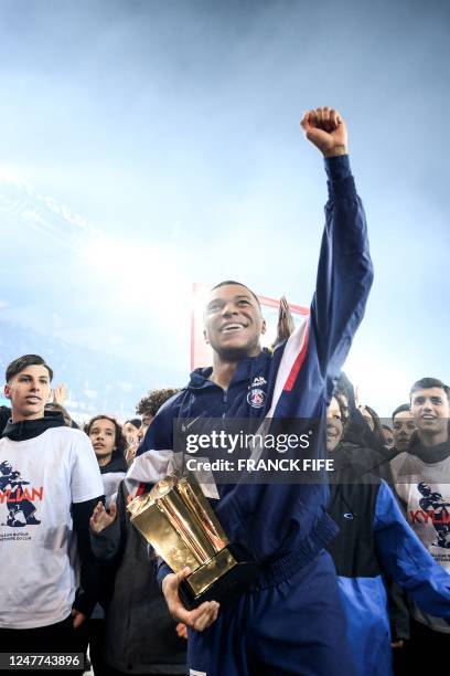 Paris Saint-Germain's French forward Kylian Mbappe cheer supporters at the end of a ceremony after he became Paris Saint-Germain's all-time top...