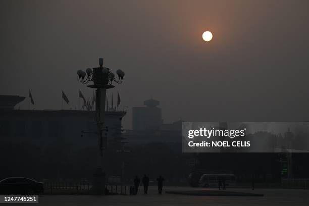 The sun rises above the Great Hall of the People ahead of the opening session of the National People's Congress in Beijing on March 5, 2023.