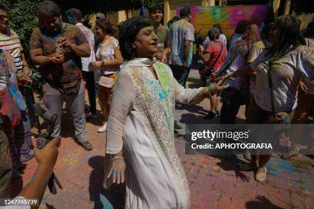 Woman of Indian origin dances with Salvadorans while colored powders are thrown during the celebration of the traditional Hindu Holi Festival 2023 at...