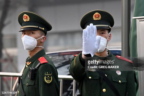 Paramilitary police stand guard south of the Great Hall of the People before the opening session of the National Peoples Congress in Beijing on March...