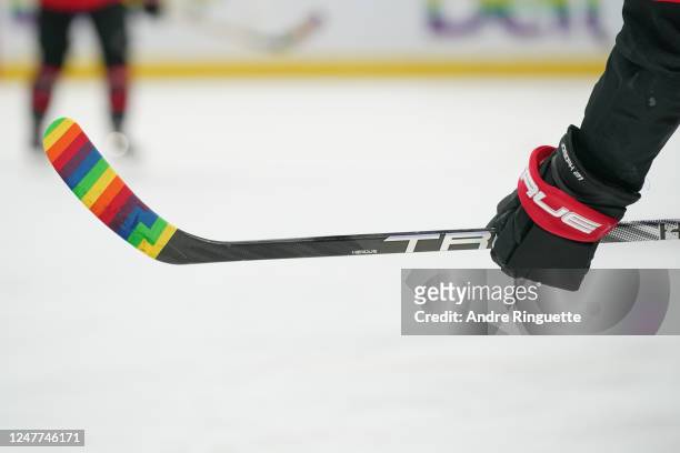 Mathieu Joseph of the Ottawa Senators warms up with rainbow tape on his stick during warmup on Pride Night prior to a game against the Columbus Blue...