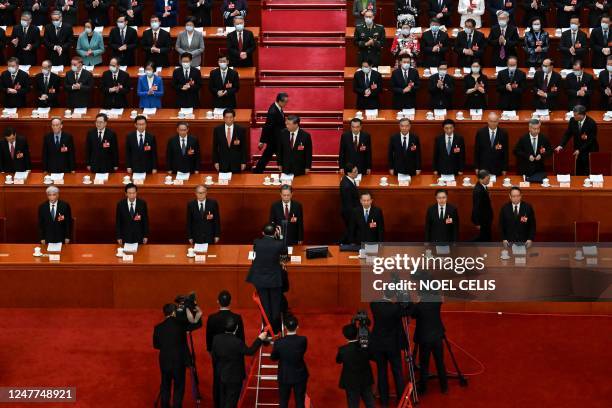 State media staff members work as China's President Xi Jinping and other Chinese leaders arrive for the opening session of the National People's...