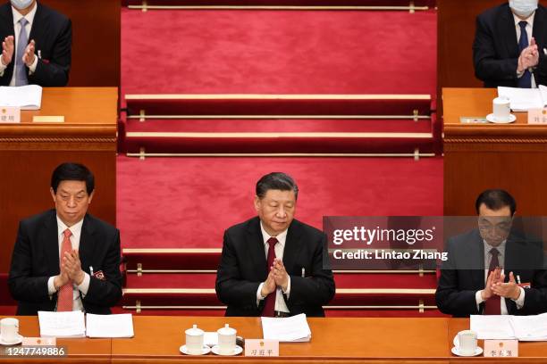 Chinese President Xi Jinping applauds during the opening of the first session of the 14th National People's Congress at The Great Hall of People on...