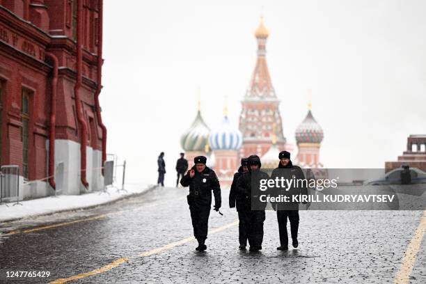 Police officers walk outside the empty Red Square prior a memorial ceremony to mark the 70th anniversary of the death of late Soviet leader Joseph...