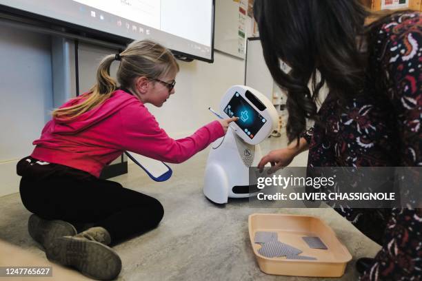 This photograph taken on March 3, 2023 shows a child attending a class with Buddy, a TED-i robot, at the Paul Chevalier school in Rillieux-La-Pape,...