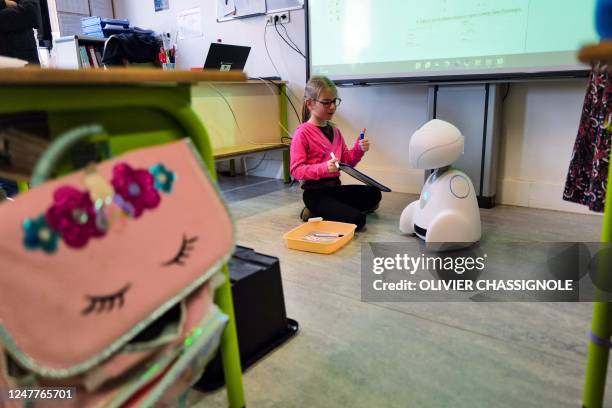 This photograph taken on March 3, 2023 shows a child attending a class with Buddy, a TED-i robot, at the Paul Chevalier school in Rillieux-La-Pape,...