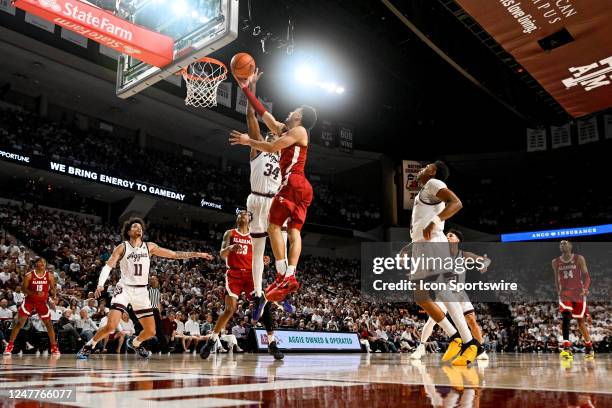 Alabama Crimson Tide guard Jahvon Quinerly attempts a finger roll as Texas A&M Aggies forward Julius Marble defends during the basketball game...