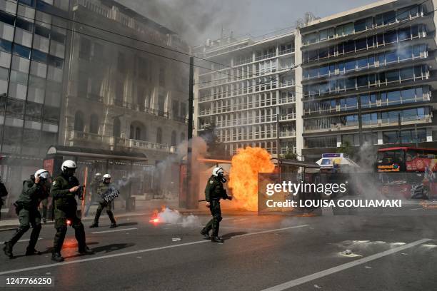 Riot police react as a petrol bomb explodes during clashes with protesters at a demonstration in Athens on March 5 following a deadly train accident...