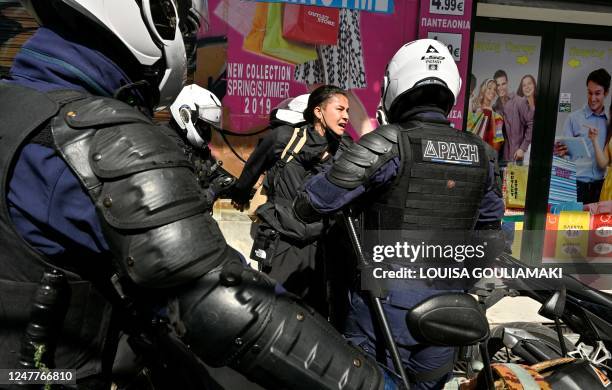 Riot police detain a protester during a demonstration in Athens on March 5 following a deadly train accident late on February 28. - Violent clashes...