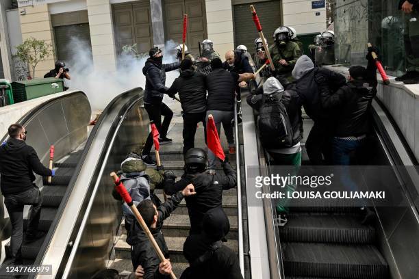 Protesters clash with riot police at the entrance of a metro station during a demonstration in Athens on March 5 following a deadly train accident...
