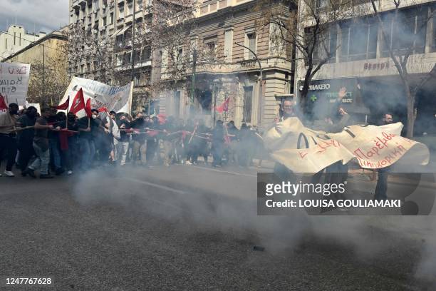 Protesters react to tear gas during clashes with police at a demonstration in Athens on March 5 following a deadly train accident late on February...