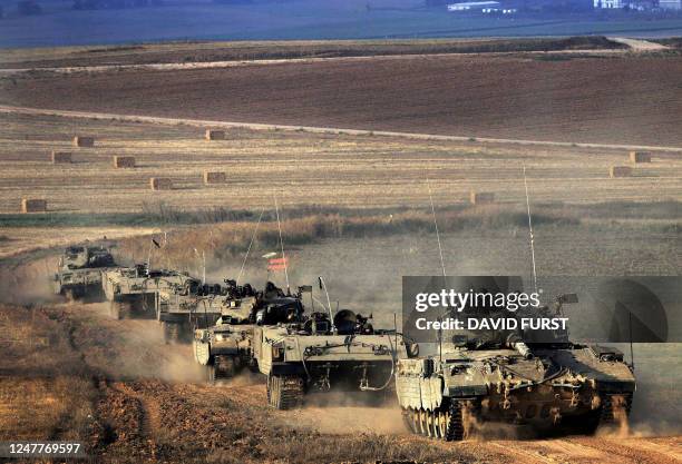 Column of Israeli tanks and armored personnel carriers rolls into the northern Gaza Strip from a stretch of farmland near the Israeli Kibbutz...