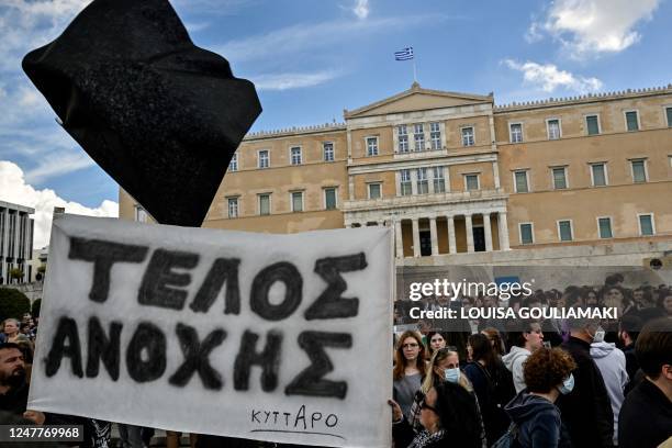 Potesters hold a banner reading "End of tolerance" and a black flag in front of the Greek parliament during a demonstration in Athens on March 5...