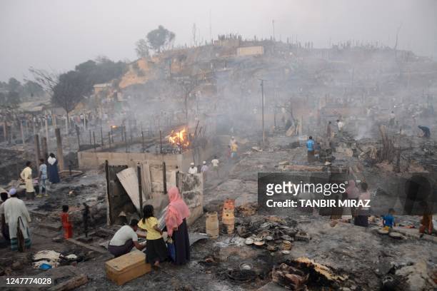 Rohingya refugees search for their belongings after a fire broke out in Balukhali refugee camp in Ukhia on March 5, 2023. - A major fire in a...