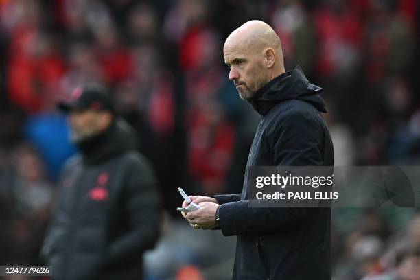 Manchester United's Dutch manager Erik ten Hag makes notes during the English Premier League football match between Liverpool and Manchester United...
