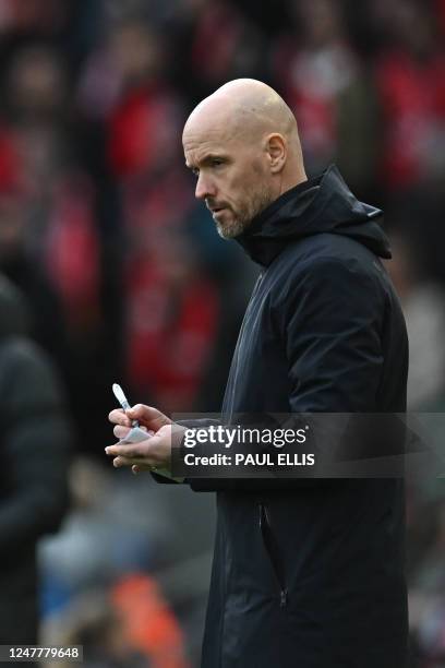 Manchester United's Dutch manager Erik ten Hag makes notes during the English Premier League football match between Liverpool and Manchester United...