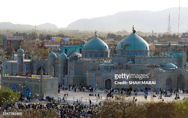 Afghans walk at the Hazrat Ali Shrine in the northern town of Mazar-i-Sharif in Balkh province on March 19, 2009. Tens of thousands of Afghans from...