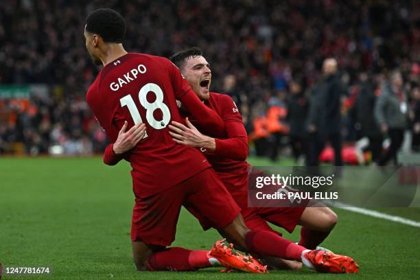 Liverpool's Dutch striker Cody Gakpo celebrates with Liverpool's Scottish defender Andrew Robertson after scoring the opening goal of the English...