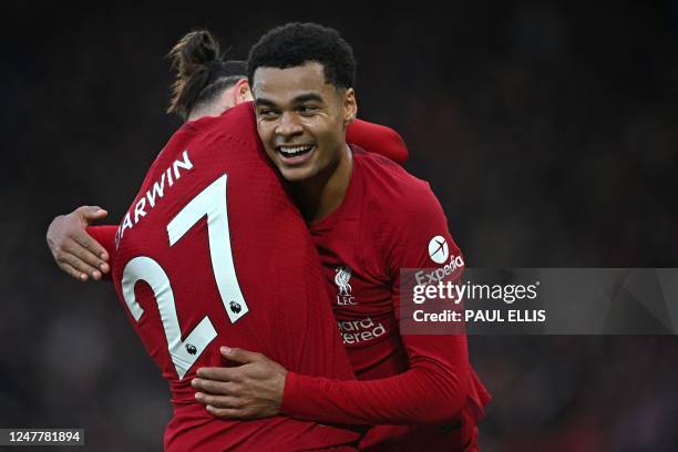 Liverpool's Dutch striker Cody Gakpo celebrates with Liverpool's Uruguayan striker Darwin Nunez after scoring the opening goal of the English Premier...