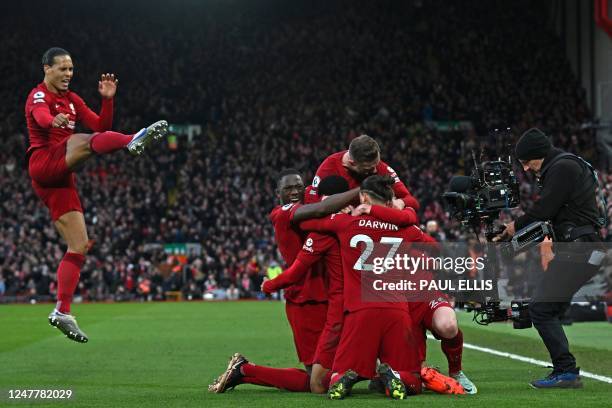 Liverpool's Dutch striker Cody Gakpo celebrates with teammates after scoring the opening goal of the English Premier League football match between...