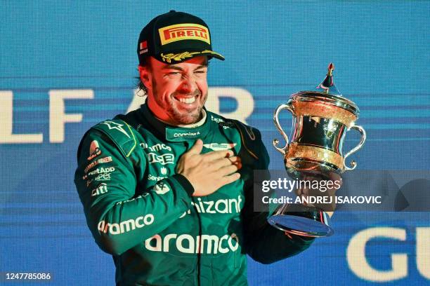 Aston Martin's Spanish driver Fernando Alonso celebrates on the podium with the third place trophy after the Bahrain Formula One Grand Prix at the...