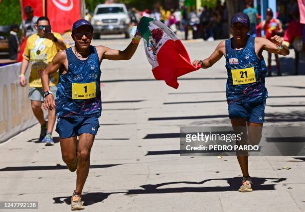Jupiter Carera and his brother Juan Carlos Carera cross the finish line of the ultramarathon "Caballo Blanco" in the Tarahumara mountains in Urique,...