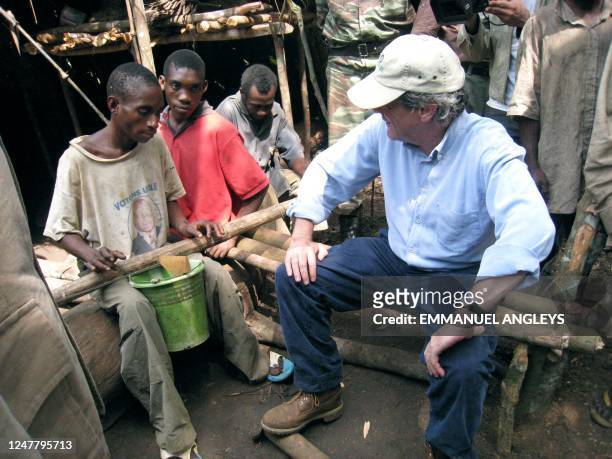 French Ecology Minister Jean-Louis Borloo looks at a pygmy man while visiting Ndoki Forest managed by CBI, Congolese Industrial wood, on May 24, 2008...