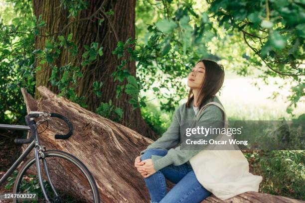 young woman connecting with nature in the park - tote bags photos et images de collection