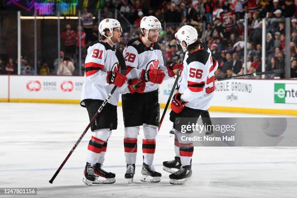 Damon Severson of the New Jersey Devils celebrates with teammates Dawson Mercer and Erik Haula after scoring a goal against the Arizona Coyotes...