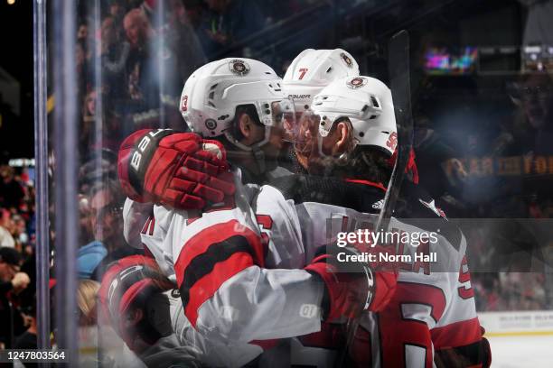 Nico Hischier of the New Jersey Devils celebrates with teammates Erik Haula and Dougie Hamilton after scoring a goal in overtime against the Arizona...