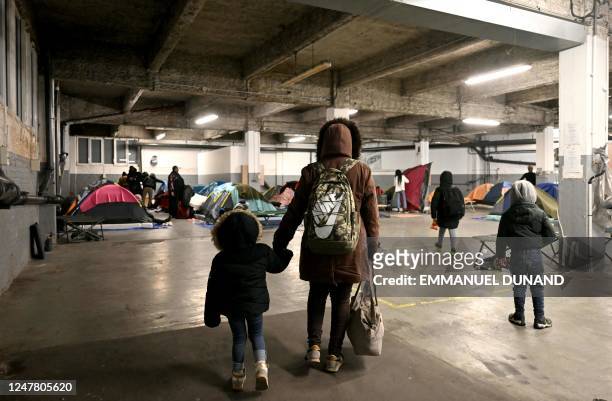 People in administrative difficulties, including undocumented and migrants and asylum seekers, arrive at a parking lot transformed into a temporary...