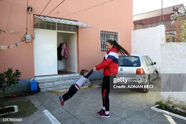 Goalkeeper Ardiola Raxhimi of the Vllaznia women's football team, plays with son Anuar at her home, after a training session in the city of Shkodra,...