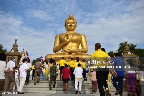 Buddhist devotees towards a giant Buddha statue as they mark Makha Bucha Day in the southern Thai town of Narathiwat on March 6, 2023.