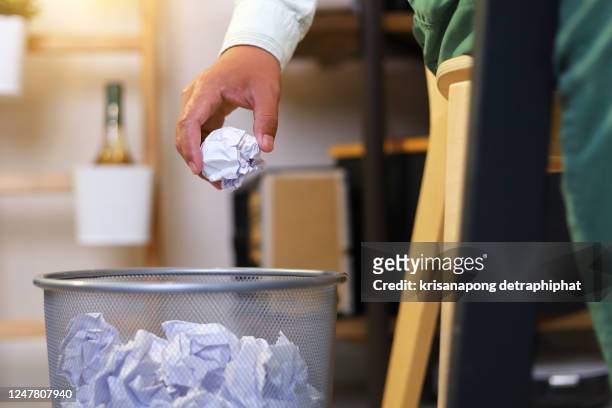 man's hand throwing crumpled paper in basket. - throwing rubbish stock pictures, royalty-free photos & images