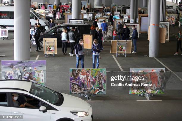 Visitors, sitting in their cars ,drive through at the "Nachtbroetchen 2.0" drive-in Pop-up-Exhibition during the Coronavirus crisis at Airport...