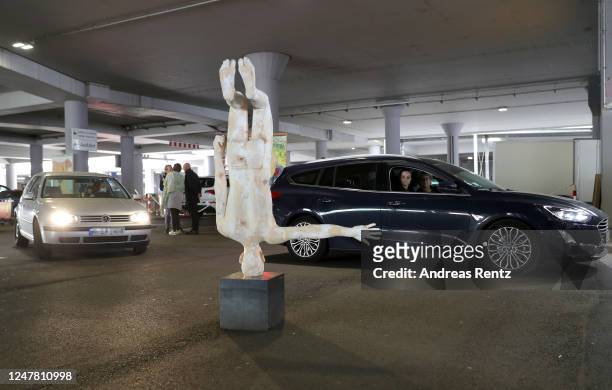Visitors, sitting in their cars, past drive a sculpture by artist Hubert Mussner at the "Nachtbroetchen 2.0" drive-in Pop-up-Exhibition during the...