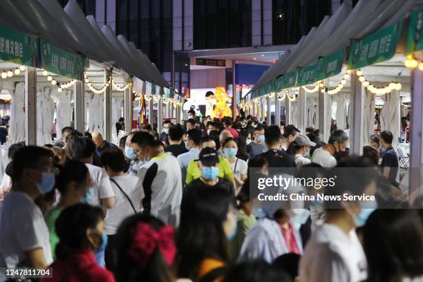 People crowd around street vendors during a night market at National Exhibition and Convention Center on June 6, 2020 in Shanghai, China.