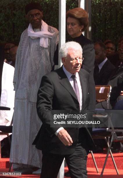 French Cooperation Minister Charles Josselin returns to his chair after presenting his condolence to Senegalese President Abdoulaye Wade and to...