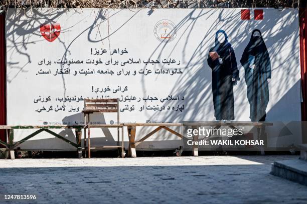 Banner ordering women to cover themselves with a Hijab is pictured at a private university after the universities were reopened in Kabul on March 6,...