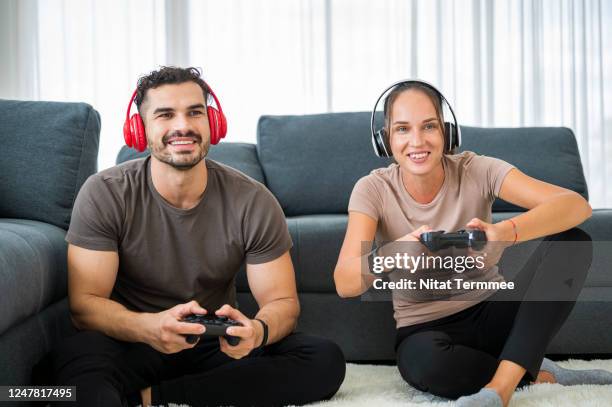 young couple playing video games together during home quarantine. - quarantine stock pictures, royalty-free photos & images