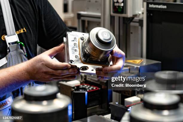 An employee checks a cylinder component for the MK C2 brake system module at on the production line at the the Continental AG manufacturing plant in...