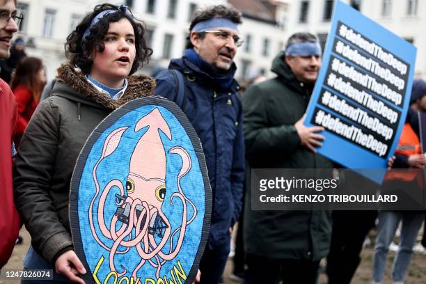 Activists take part at a "Look Down action" rally to stop deep sea mining outside the European Parliament in Brussels on March 6, 2023.
