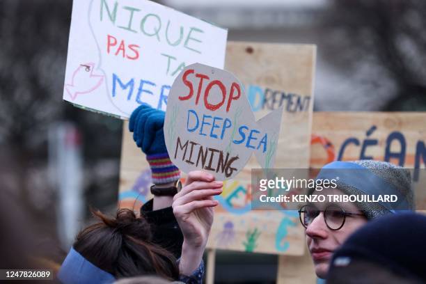 Activists take part at a "Look Down action" rally to stop deep sea mining outside the European Parliament in Brussels on March 6, 2023.