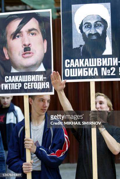 Russian members of the "Marching Together" youth pro-Kremlin political movement hold the posters with portrets of Georgian President Mikhail...