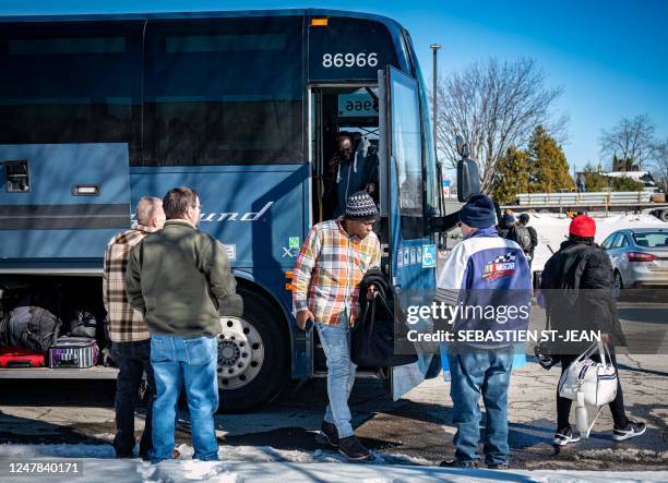Migrants exit a bus in Plattsburgh, New York, on March 3 where taxi drivers are waiting to take them to the Canadian border via the Roxham Road...